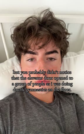 TikTok photo of a young man in bed staring blankly at the camera. Text overlay reads, 'but you probably didn't notice that the elevator door opened to a group of people as i was doing drunk gymnastics on the floor.'