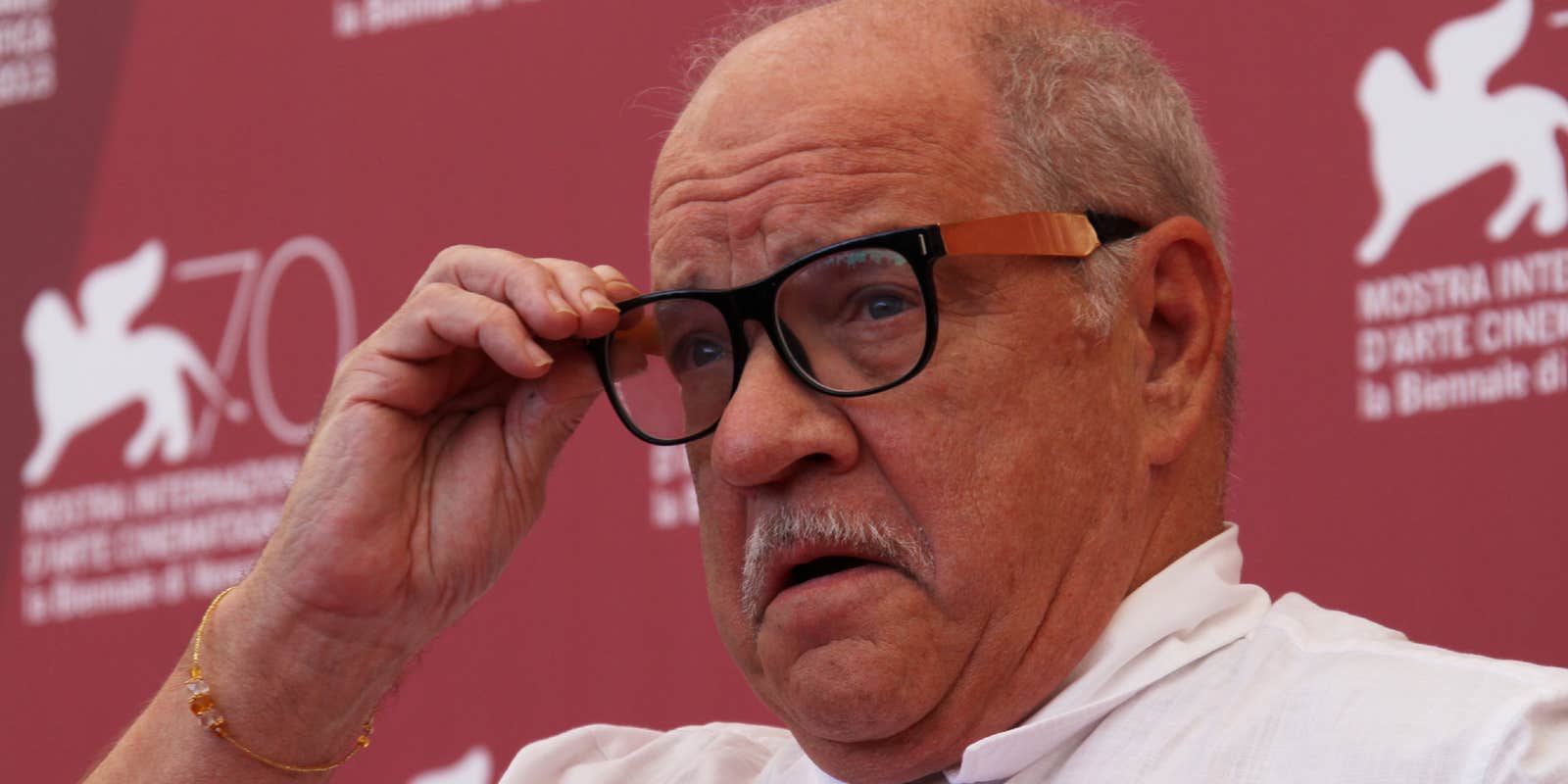 Photo of writer Paul Schrader touching his glasses pensively at a film festival.