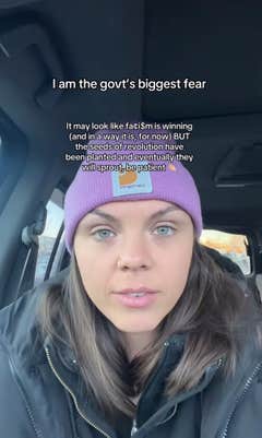 A woman in a pink beanie sitting in her car. Text overlay reads, "I am the govt's biggest fear."