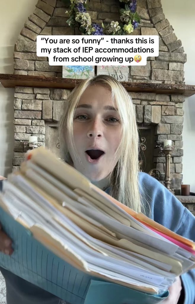 You're so funny meme trend, text overlay reads, ''You're so funny' - thanks this is my stack of IEP accommodations from school growing up (silly emoji)' with a photo of a person holding up a giant stack of folders.