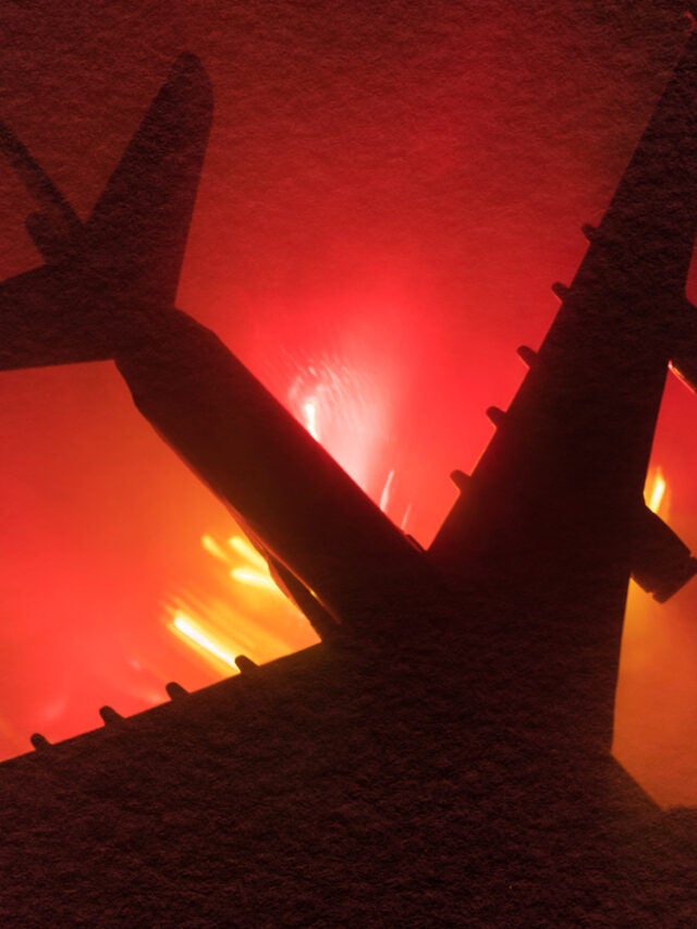 Air Crash. Burning falling plane. The plane crashed to the ground. Decorated with toy at dark fire background.