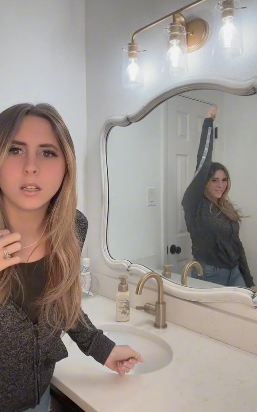 A woman at the end of her anxiety challenge video being creeped out by her reflection in the mirror