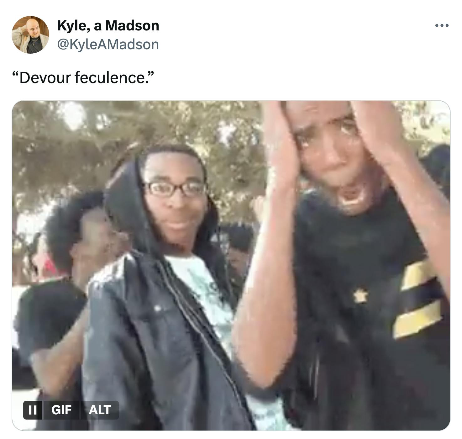 Tweet that reads, ''Devour feculence'' with the GIF of a Black man in glasses looking pleased with himself as his friend all act shocked and amazed around him.