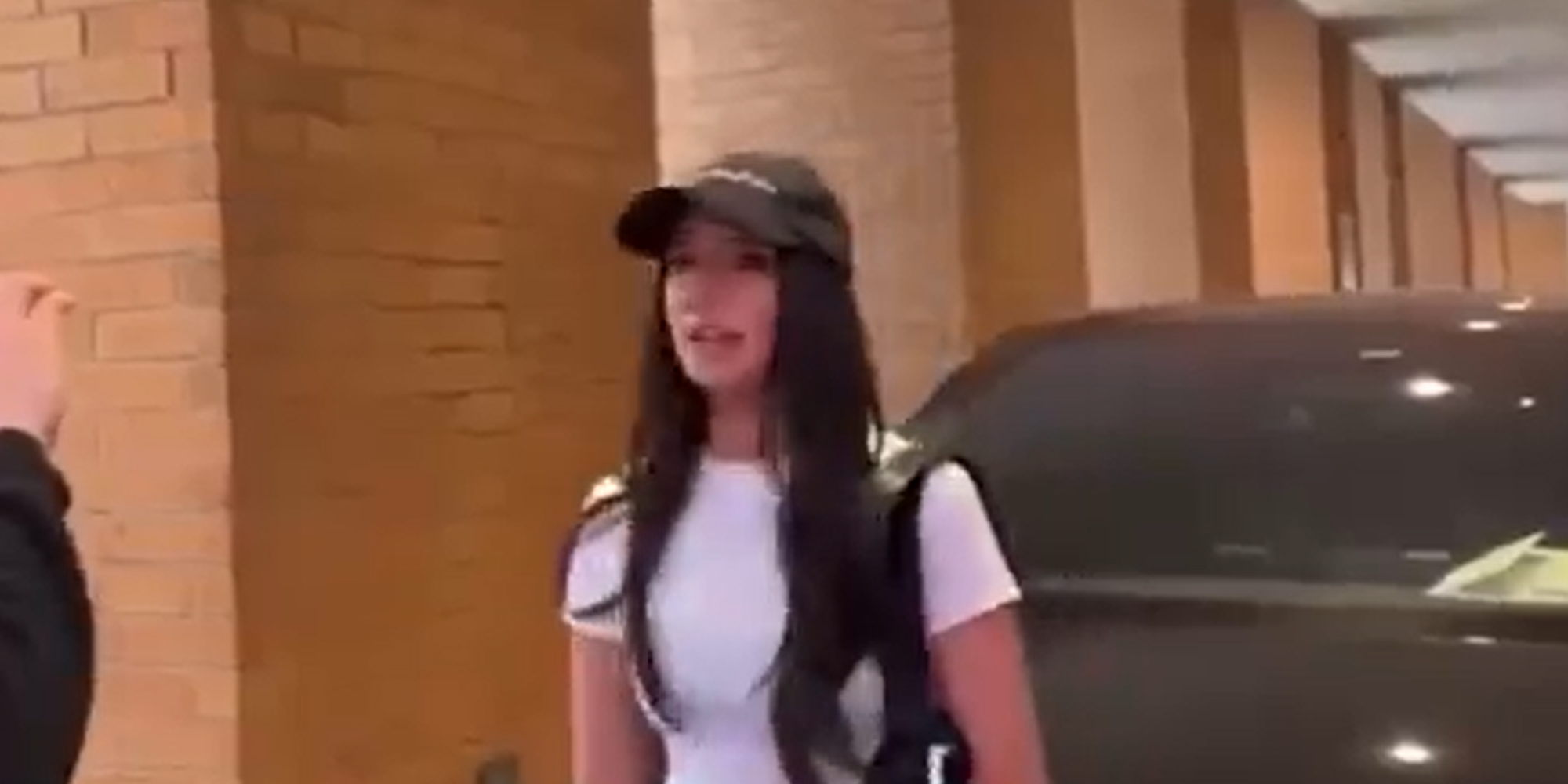 Ashley St Clair, standing in front of Tesla car