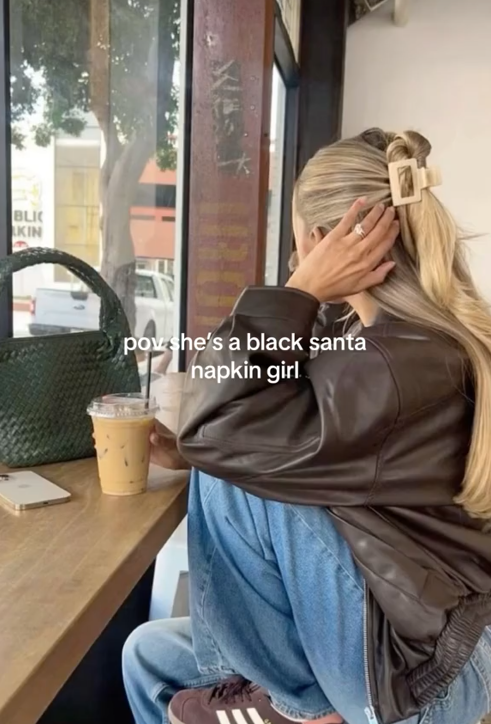 Black Santa Napkin meme TikTok video showing a white woman in a coffee shop.