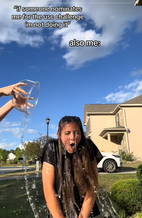 TikTok video of a woman getting splashed with water in a yard with a caption reading ''if someone nominates me for the usc challenge im not doing it' also me:'