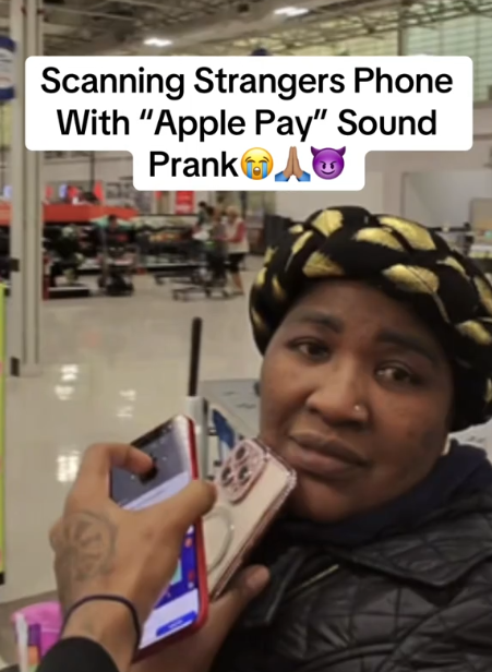 Apple Pay prank video showing someone holding up their phone to a woman's iPhone in a store.