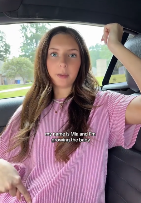 'My name is' TikTok video with a woman pointing to her stomach and saying 'I'm growing the baby.'