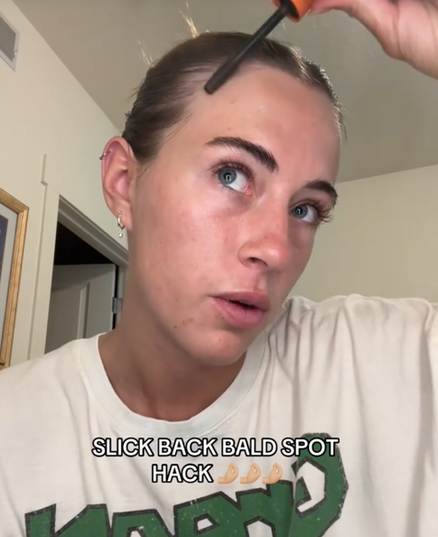 Slicked back bun traction alopecia TikTok video with a woman covering up thin hair with mascara.