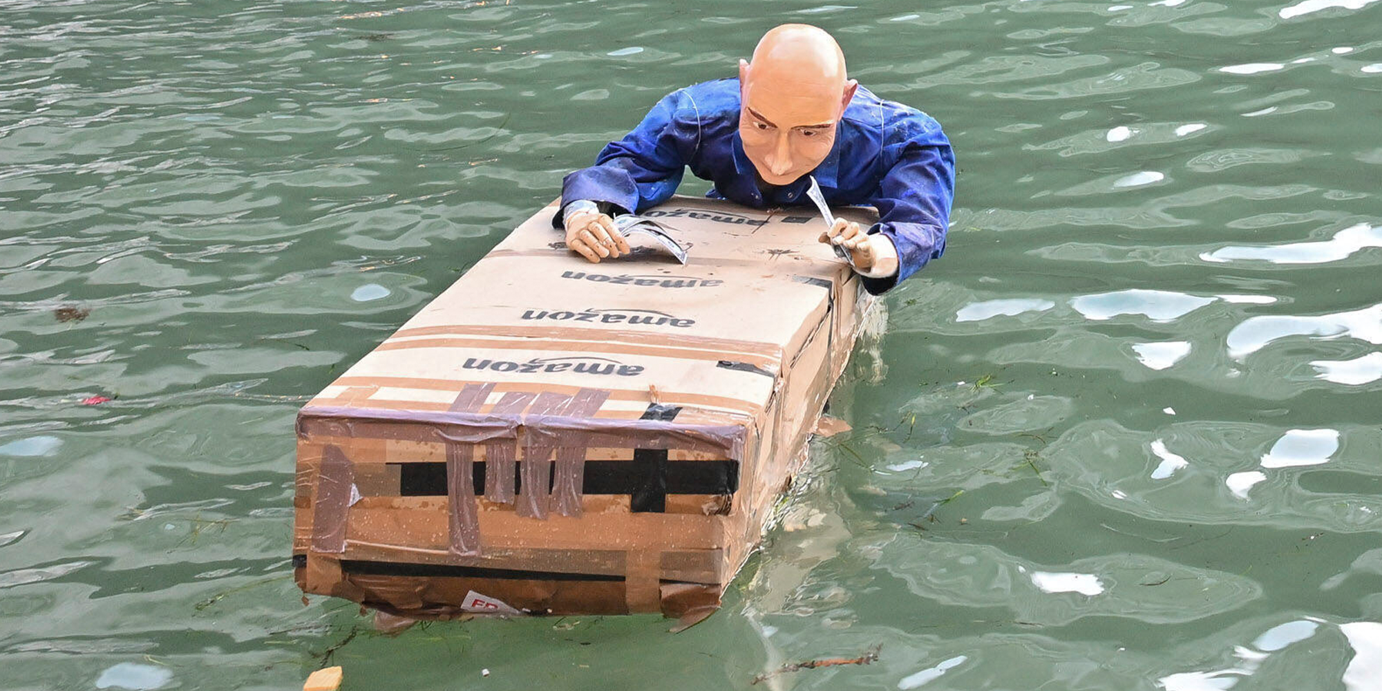 jeff bezos dummy floating in venice canal holding on to amazon boxes