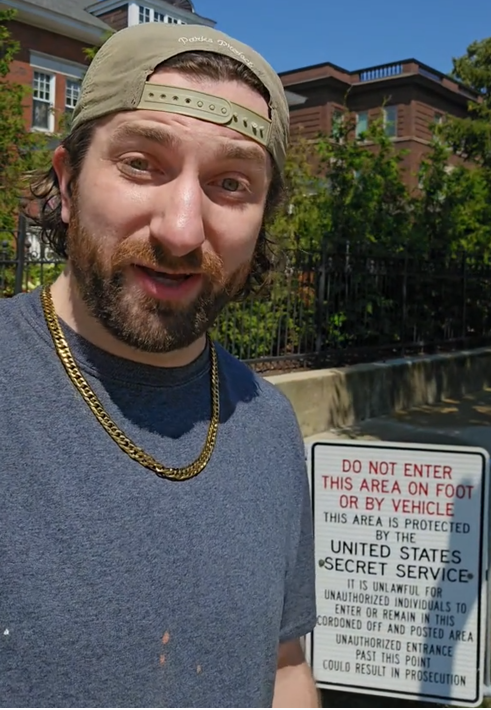 TikTok video of a man speaking to the camera in front of Barack Obama's house with a Secret Service warning sign in view.