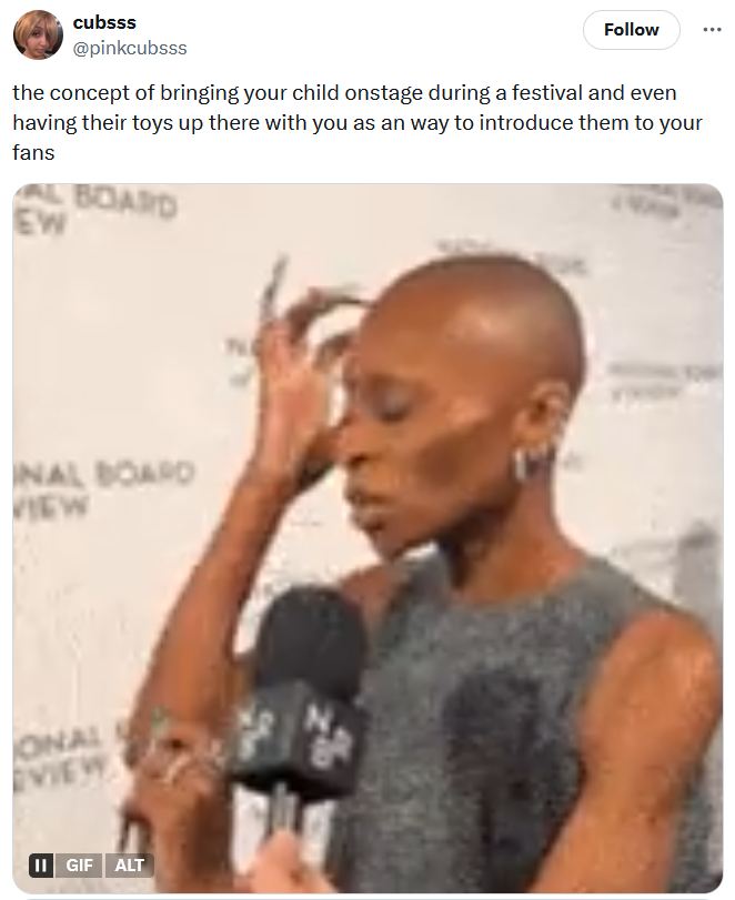 Tweet reading 'the concept of bringing your child onstage during a festival and even having their toys up there with you as an way to introduce them to your fans' with a gif of a woman touching her head.
