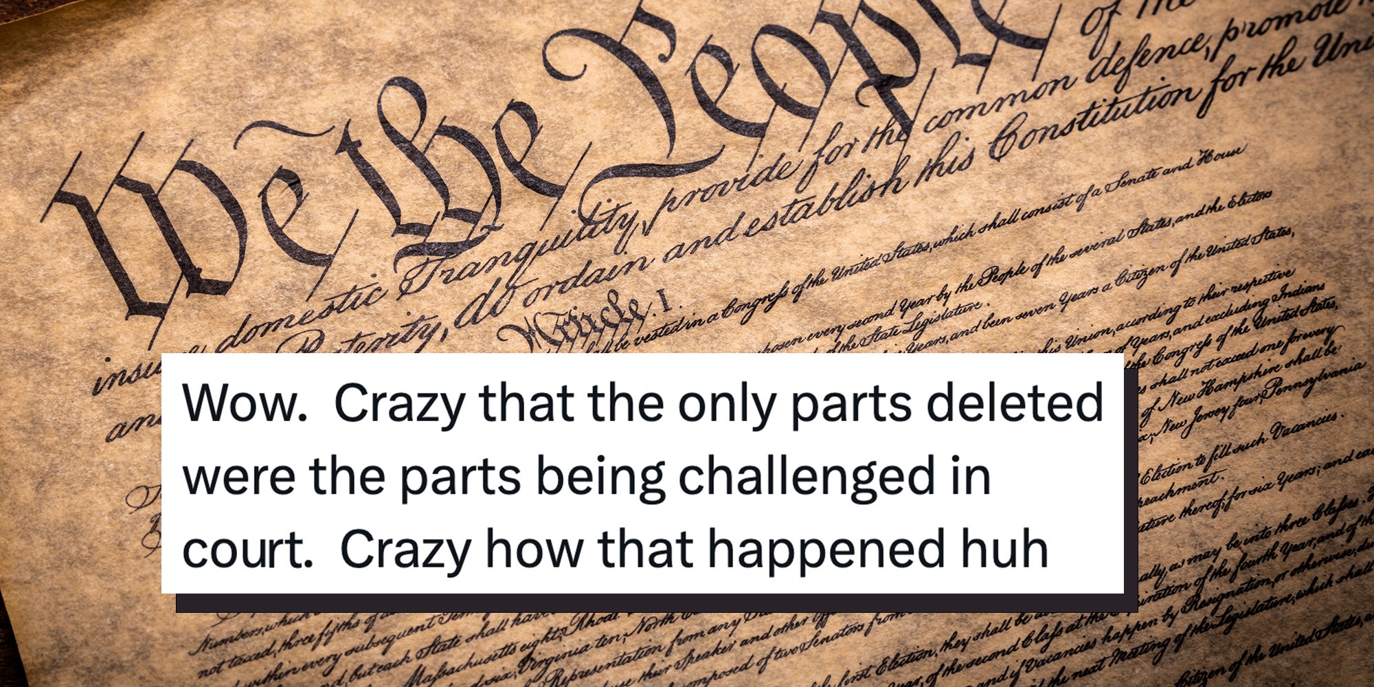 A copy of the Constitution of the United Sates of American on a wooden background. Tweet overlay reads 'Wow. Crazy that the only parts deleted were the parts being challenged in court. Crazy how that happened huh.'