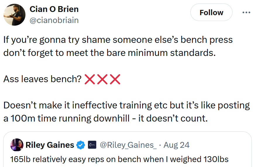 Tweet reading 'If you’re gonna try shame someone else’s bench press don’t forget to meet the bare minimum standards. Ass leaves bench? Doesn’t make it ineffective training etc but it’s like posting a 100m time running downhill - it doesn’t count.'