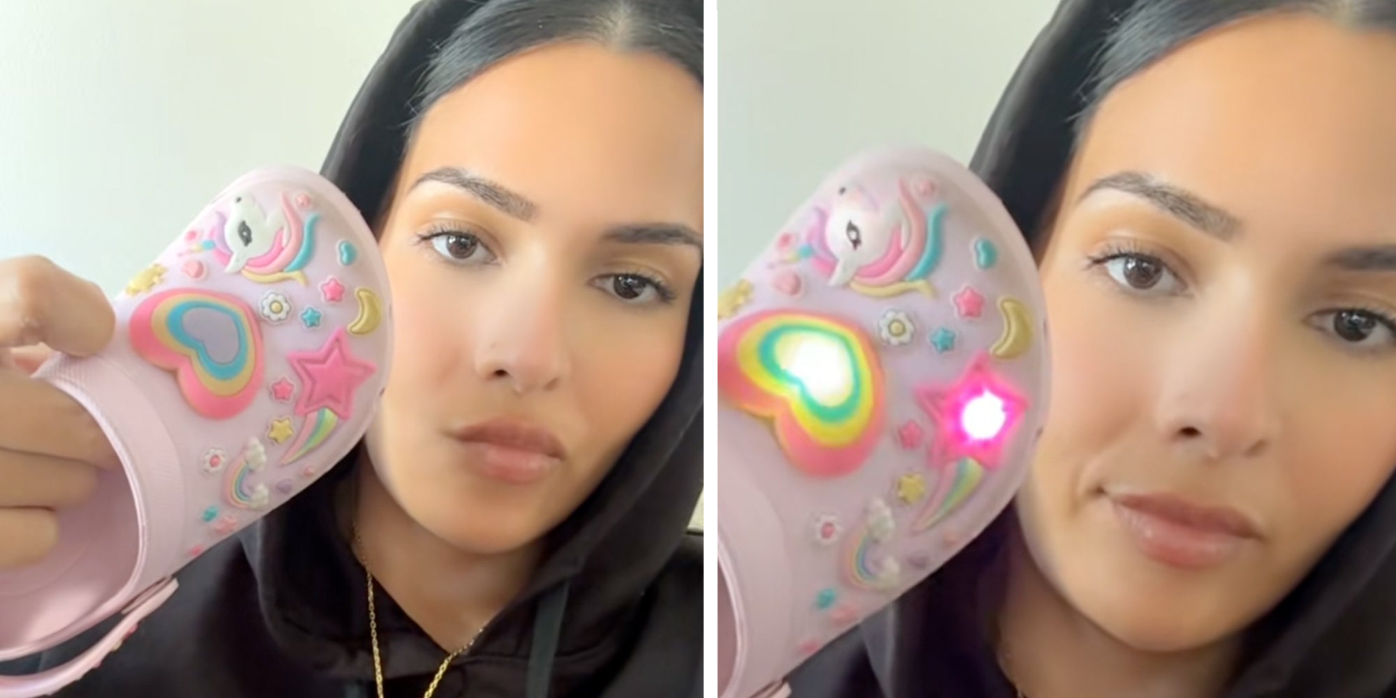 Woman in a black hoodie holding up a light-up pink croc with a light-up heart, unicorn, and star on it.