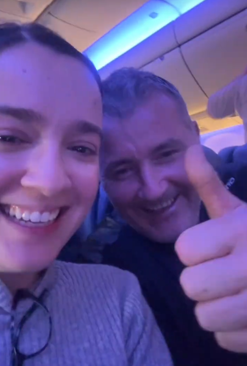 TikTok video showing a woman and a man giving a thumbs up on a plane.