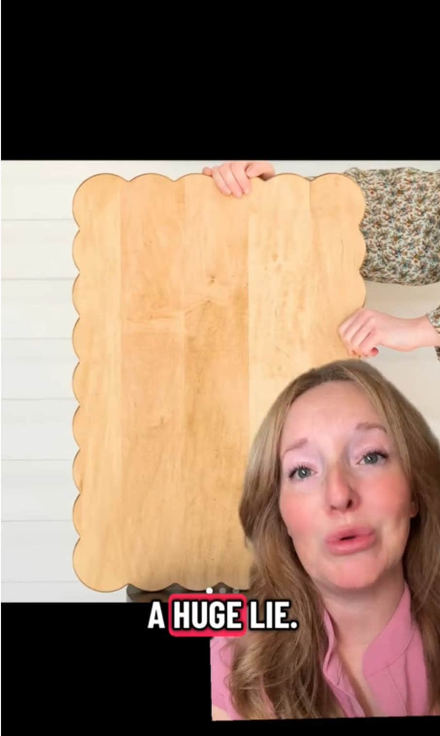 Vídeo TikTok de uma mulher dizendo 'uma grande mentira' sobre a imagem de uma grande tábua de madeira recortada.