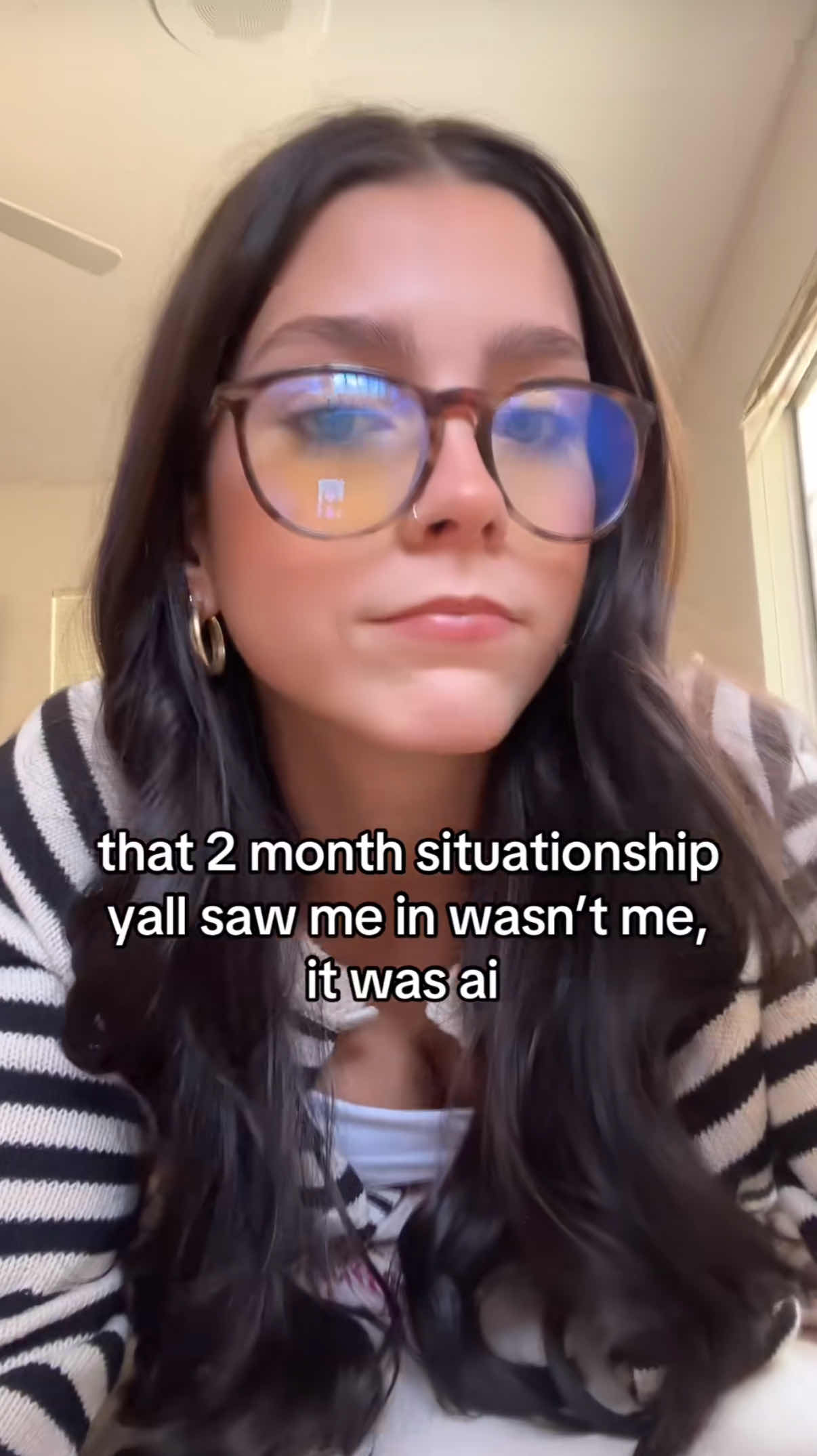 A brunette woman in big glasses staring down at the camera. Text overlay reads, "that 2 month situationship yall saw me in wasn't me, it was ai."