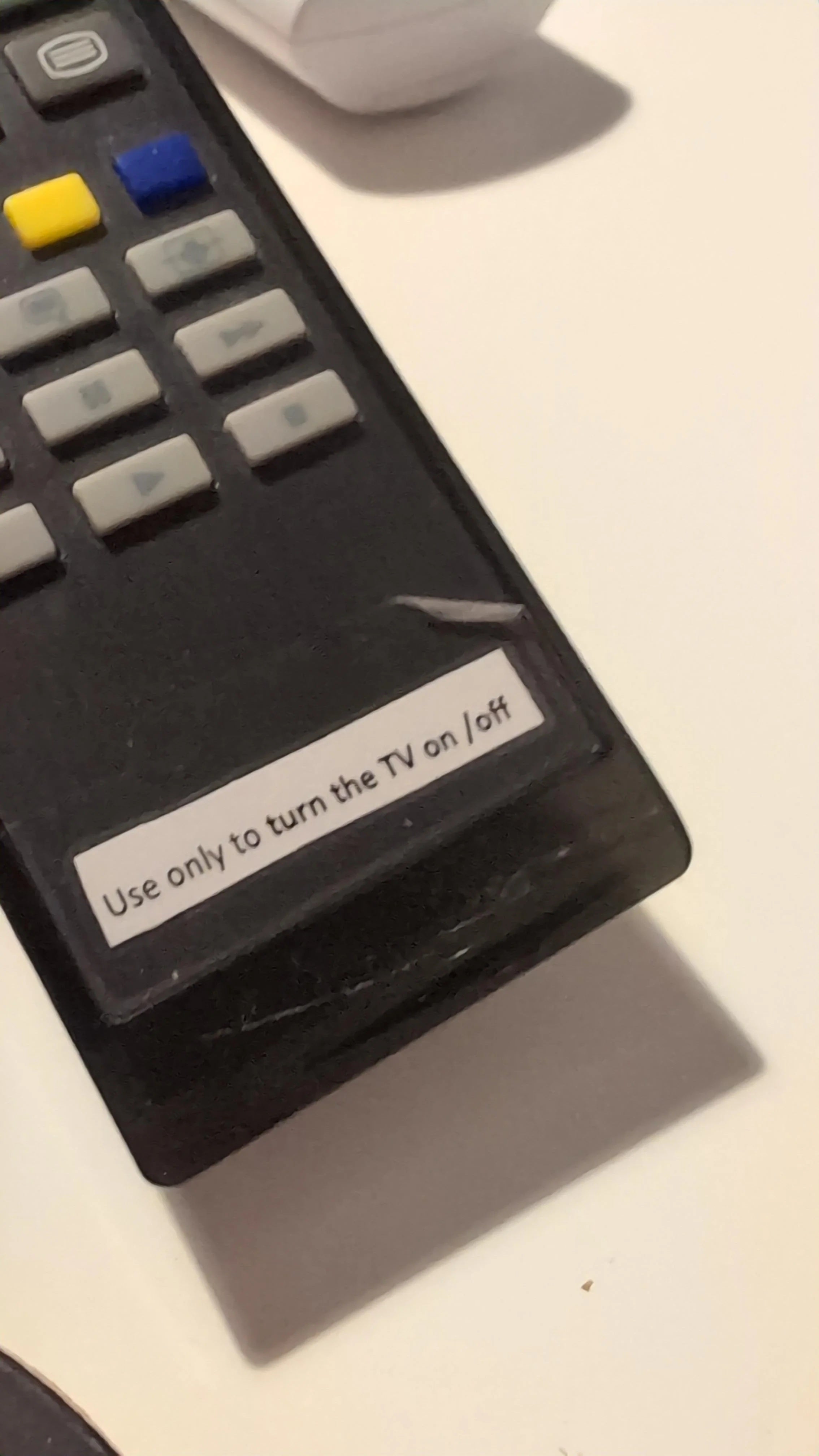 Photo of an old TV remote with a label at the bottom reading 'Use only to turn the TV on/off.'