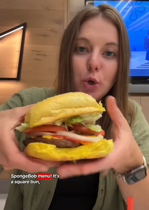 TikTok video of a woman holding up the Burger King Krabby Whopper to the camera.