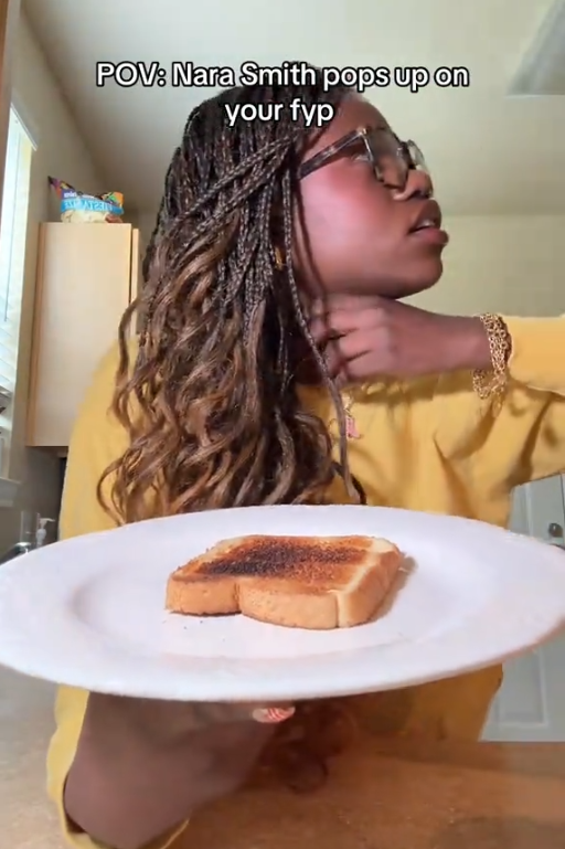 TikTok video of a woman holding a white plate with a piece of toast on it while choking herself. The caption reads ''POV: Nara Smith pops up on your fyp'