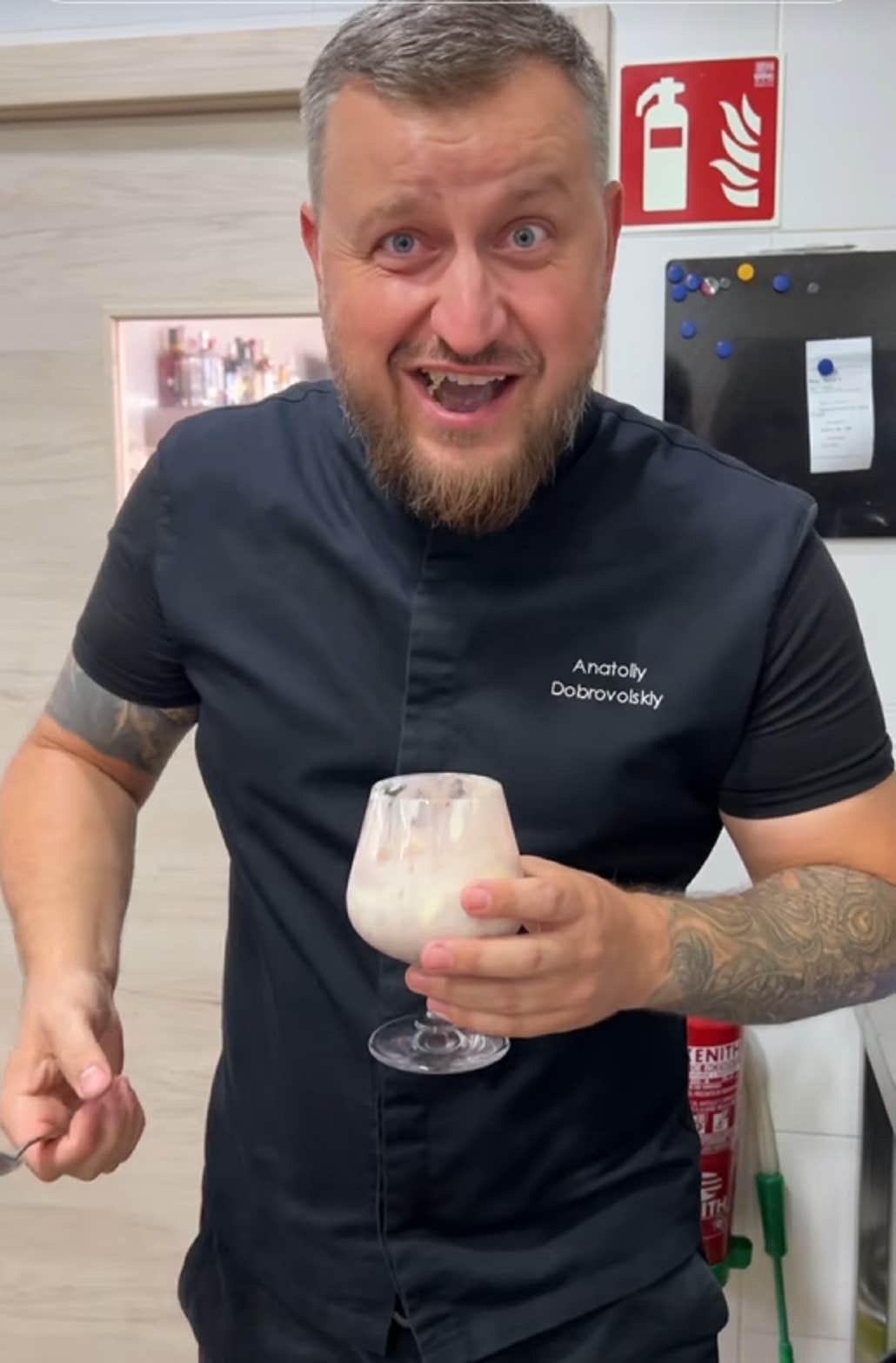 Vídeo de um chef sorrindo para a câmera enquanto segura uma taça de coquetel cheia de vinho e sorvete.