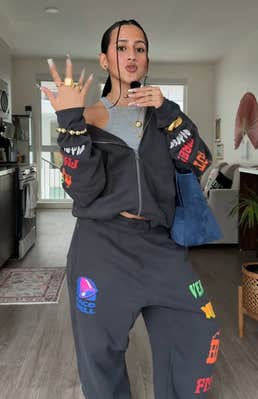 TikTok video with a woman speaking into a mic as she models the Taco Bell x Hollister collab hoodie and sweatpants.