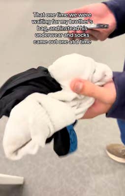 Hugh with handful of socks at baggage claim with onscreen text, “That one time we were waiting for my brother’s bag, and instead his underwear and socks came out one at a time.”
