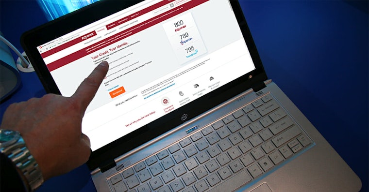 Man pointing at Equifax website on laptop
