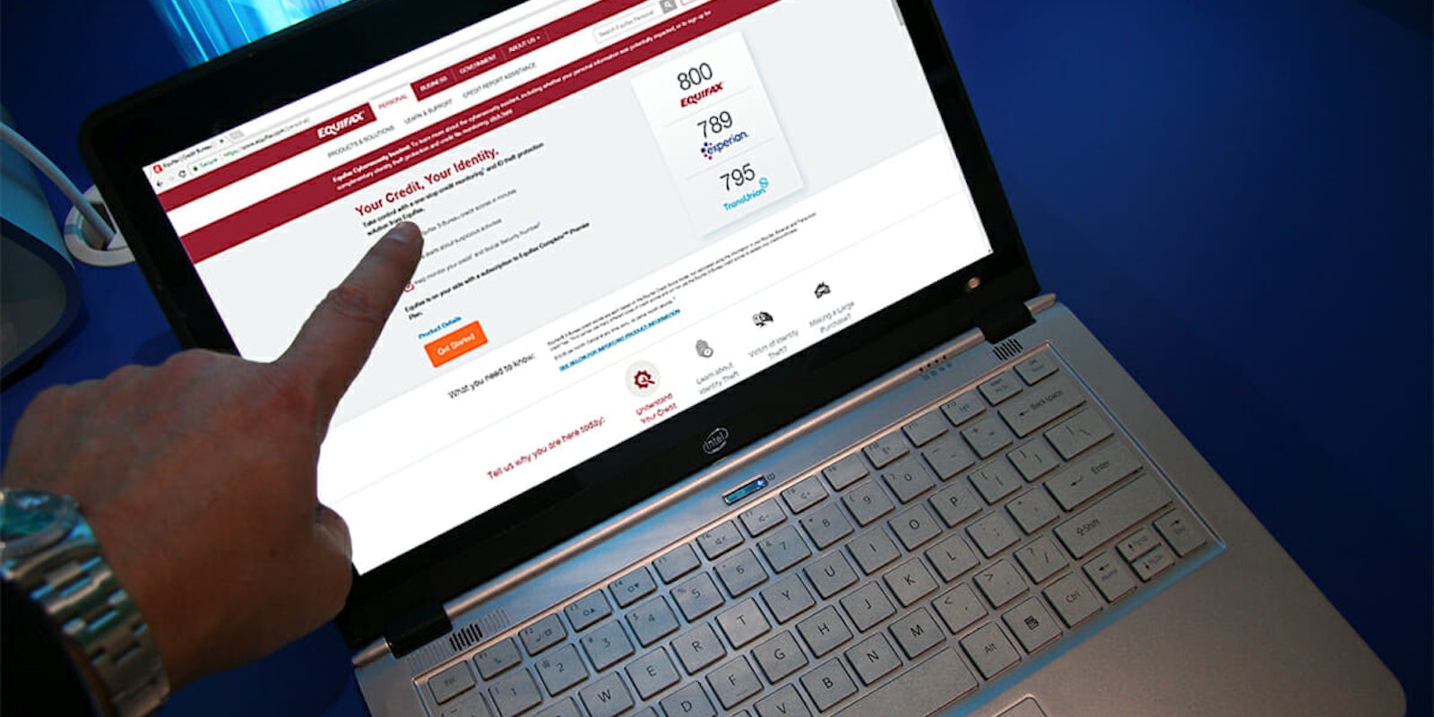 Man pointing at Equifax website on laptop