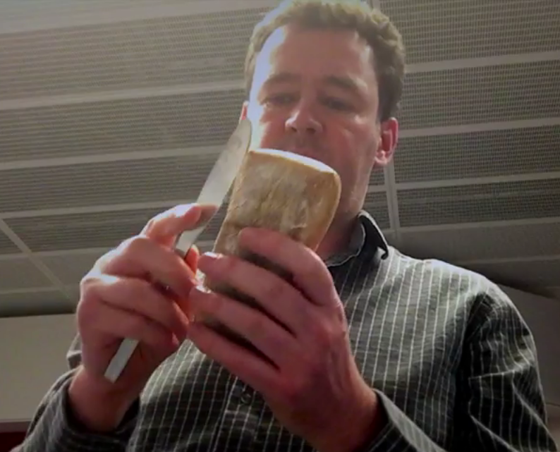 man cuts bread with table knife