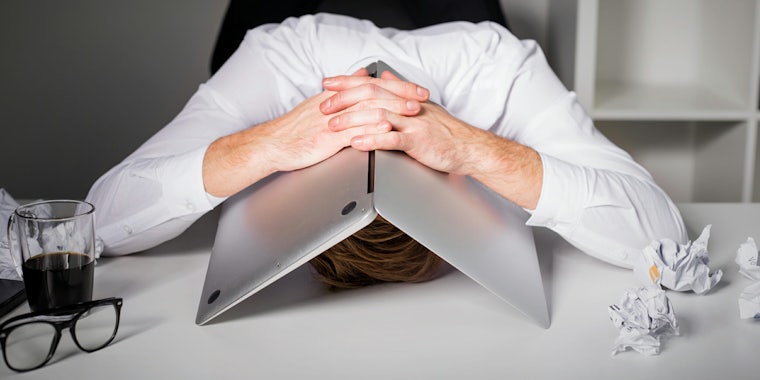 Person covering head with laptop