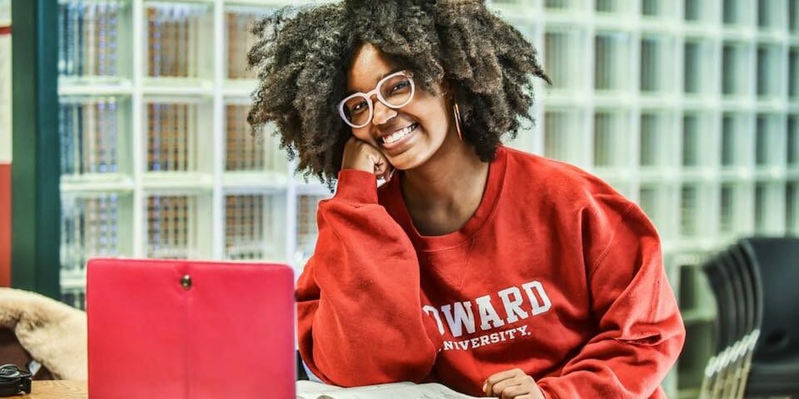 Woman on computer wearing Howard sweatshirt
