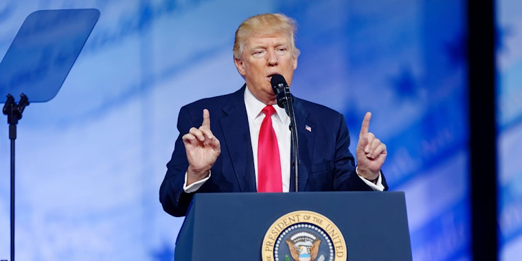 President Trump speaking at an event behind a podium bearing the seal of the U.S. president.