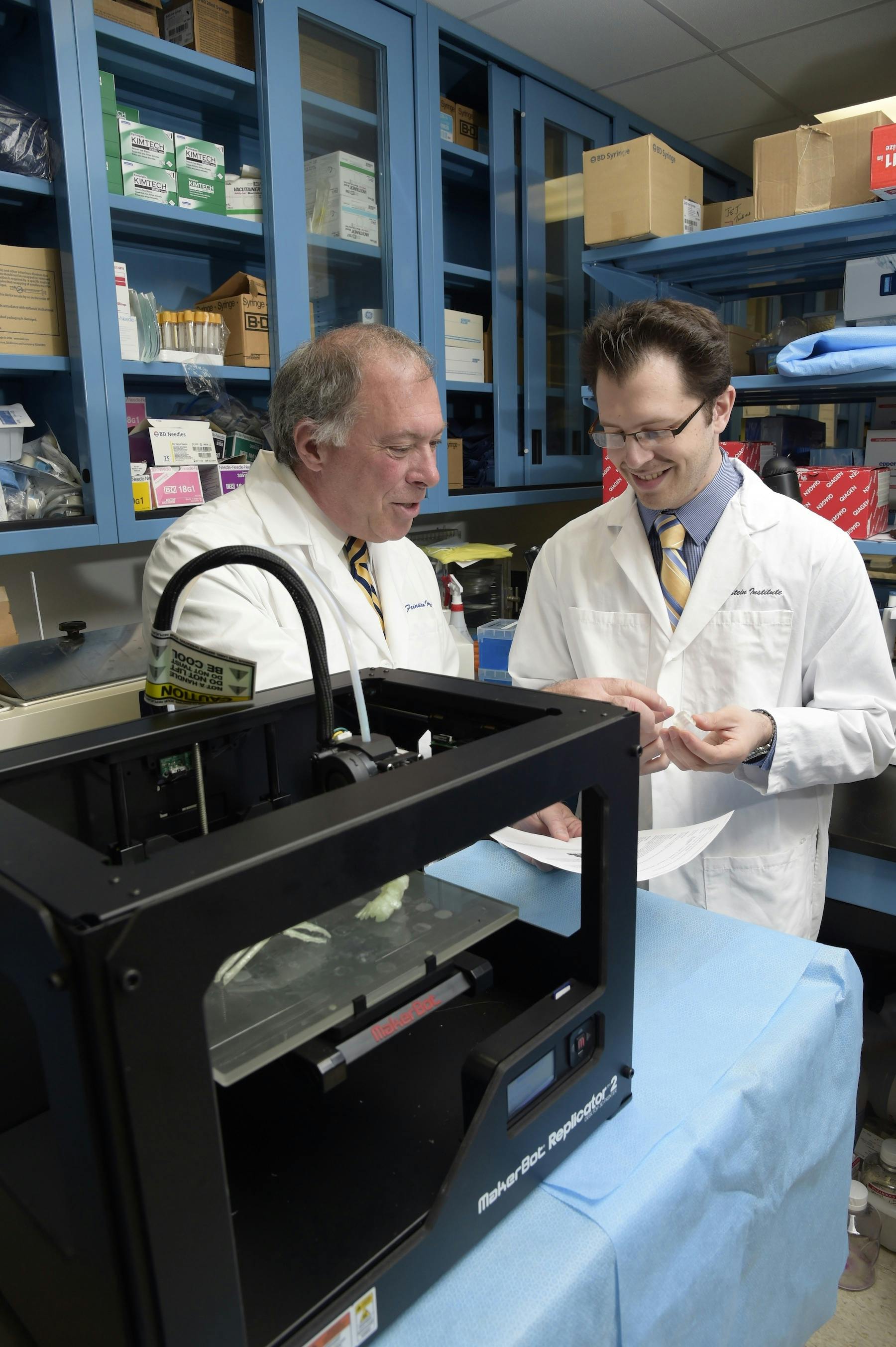 Daniel A. Grande, PhD, director of the Orthopedic Research Laboratory at the Feinstein Institute, and Todd Goldstein, an investigator at the Feinstein Institute, part of the North Shore-LIJ Health System, examine some of the 3D-printed parts they made on their MakerBot Replicator Desktop 3D Printer.