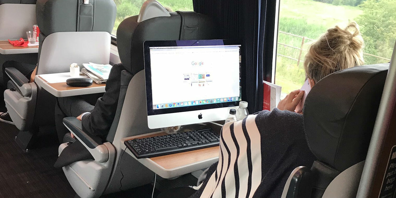 woman brings imac desktop on train