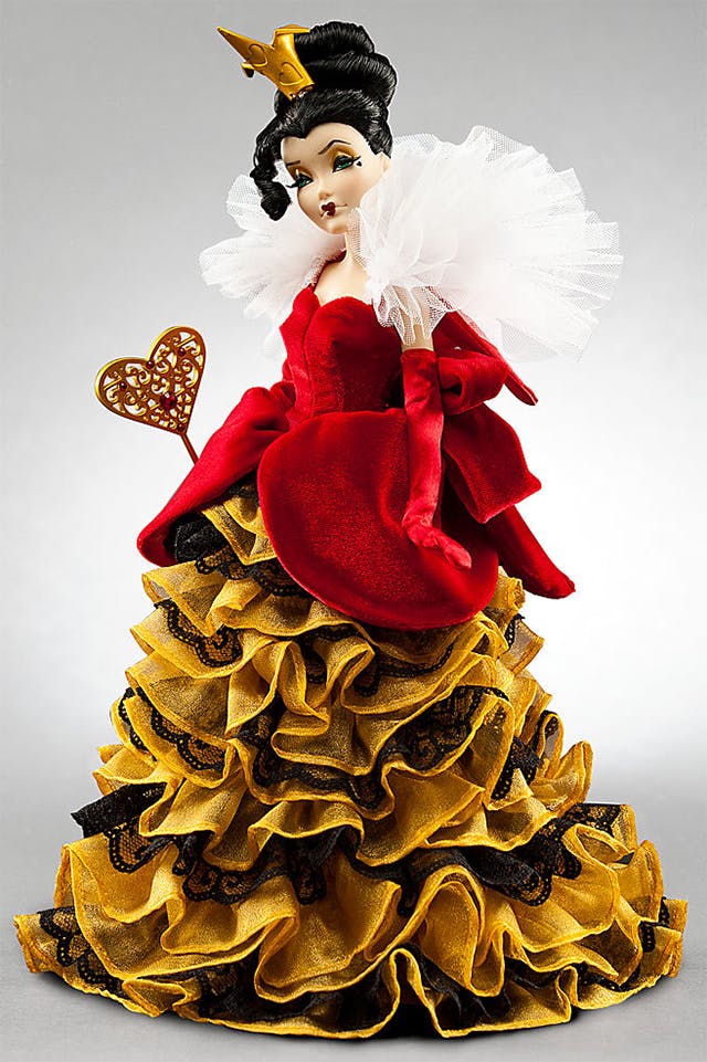 iimage of Queen of Hearts, Disney villains doll collection, showing a pretty, elegant woman clad in a red velvet dress with rich dark gold ruching on the skirt. She holds a gold wand with a large heart on the end, and has a small gold crown as in the movie Alice in Wonderland, but otherwise bears no resemblance to the Queen from the film.