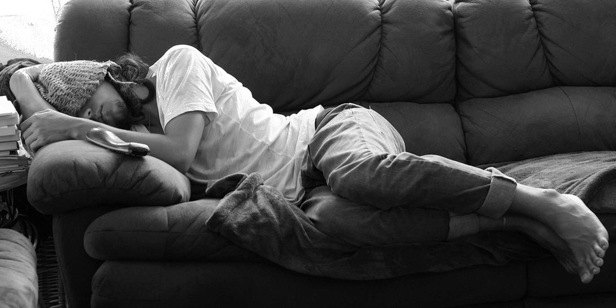Устал лежать. Мужчина лежит на диване. Спящий парень.