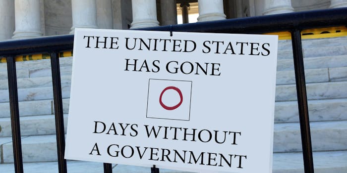 "The United States has gone 0 days without a government" sign hanging on fence in front of government building