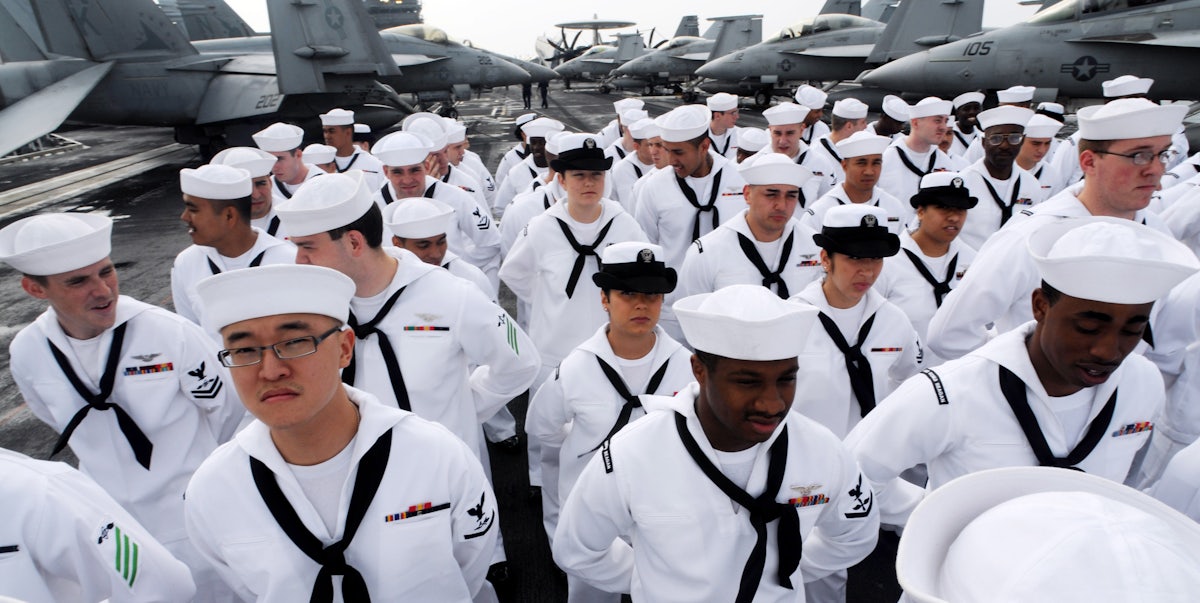 US Navy sailors standing on deck.