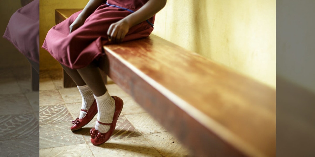 A UNICEF image showing a girl sitting on a bench symbolizing the International Day of Zero Tolerance of Female Genital Mutilation.