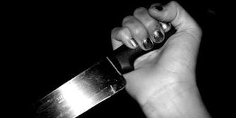 hand holding knife, stabbing downward