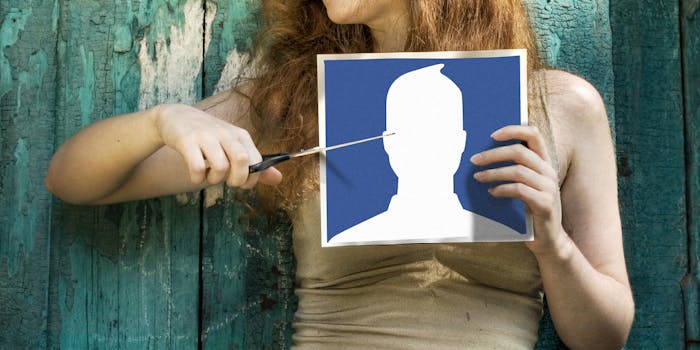 how to delete photos from facebook : Woman cutting Facebook icon photo with scissors