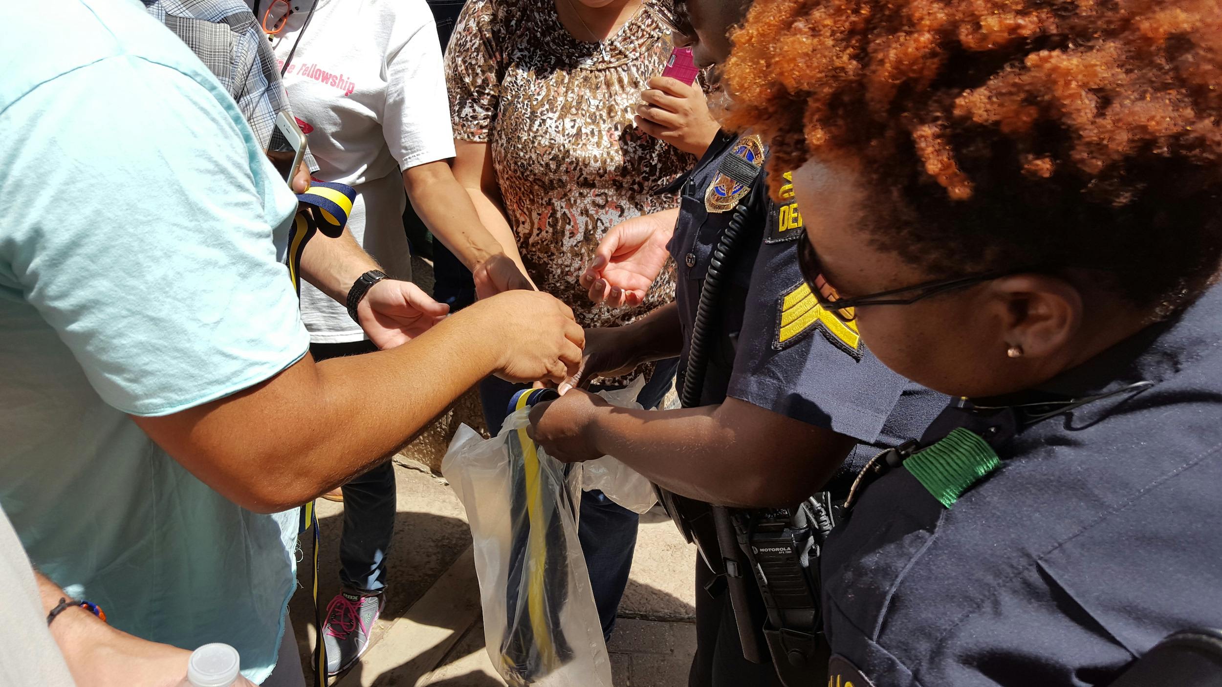 Dallas police distribute ribbons to honor the five officers killed during the June 7 massacre.