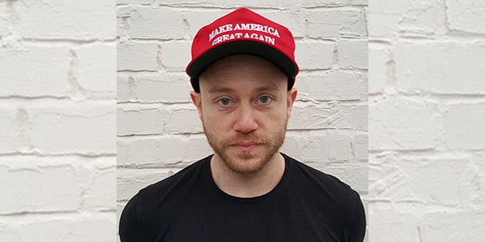 Andrew Anglin wearing Make America Great Again hat in front of white brick wall