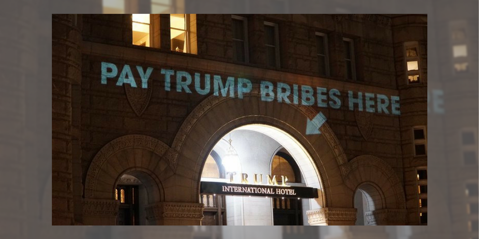 A projected message onto the Trump International Hotel in Washington D.C. that reads 'Pay Trump Bribes Here.'