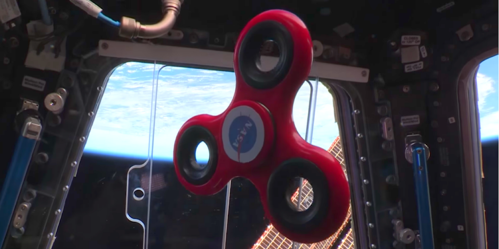 NASA international space station astronauts play with a fidget spinner in space.