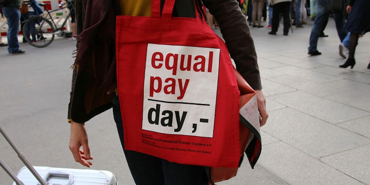 Red Equal Pay Day bag on shoulder