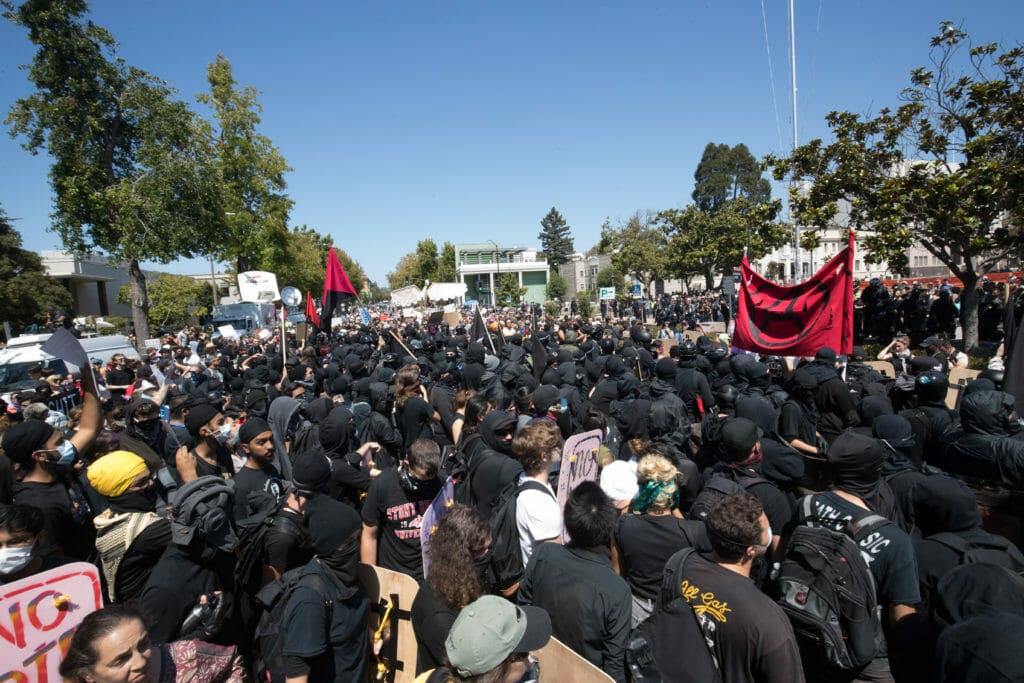 Antifa activists face off against Berkeley police, who lined up between protesters and the Martin Luther King Jr. Civic Center Park. Although news coverage of the protest focused on its flashpoints, the vast majority of those who attended were peaceful.