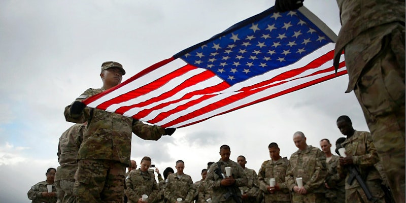 U.S. Military service members hold the U.S. flag.